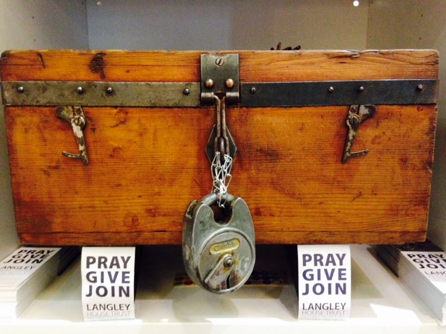 Old style wooden treasure chest with a large silver padlock on it. Around it are Langley bookmarks encouraging people to pray, give or join to help change the lives of ex-offenders